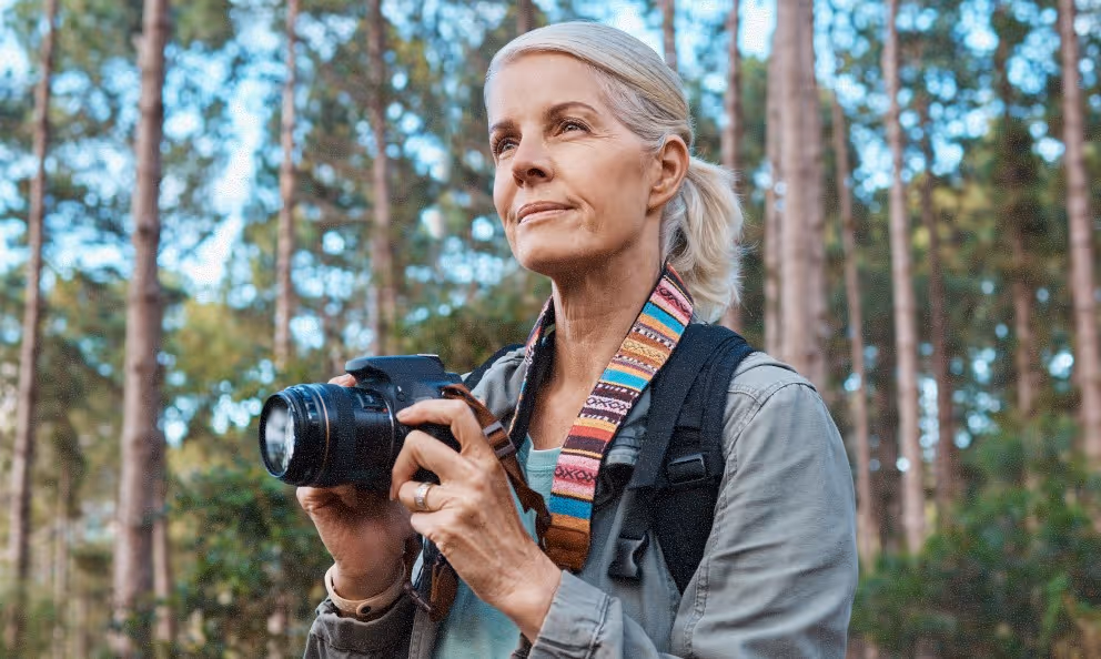 an older woman holding a professional-style camera