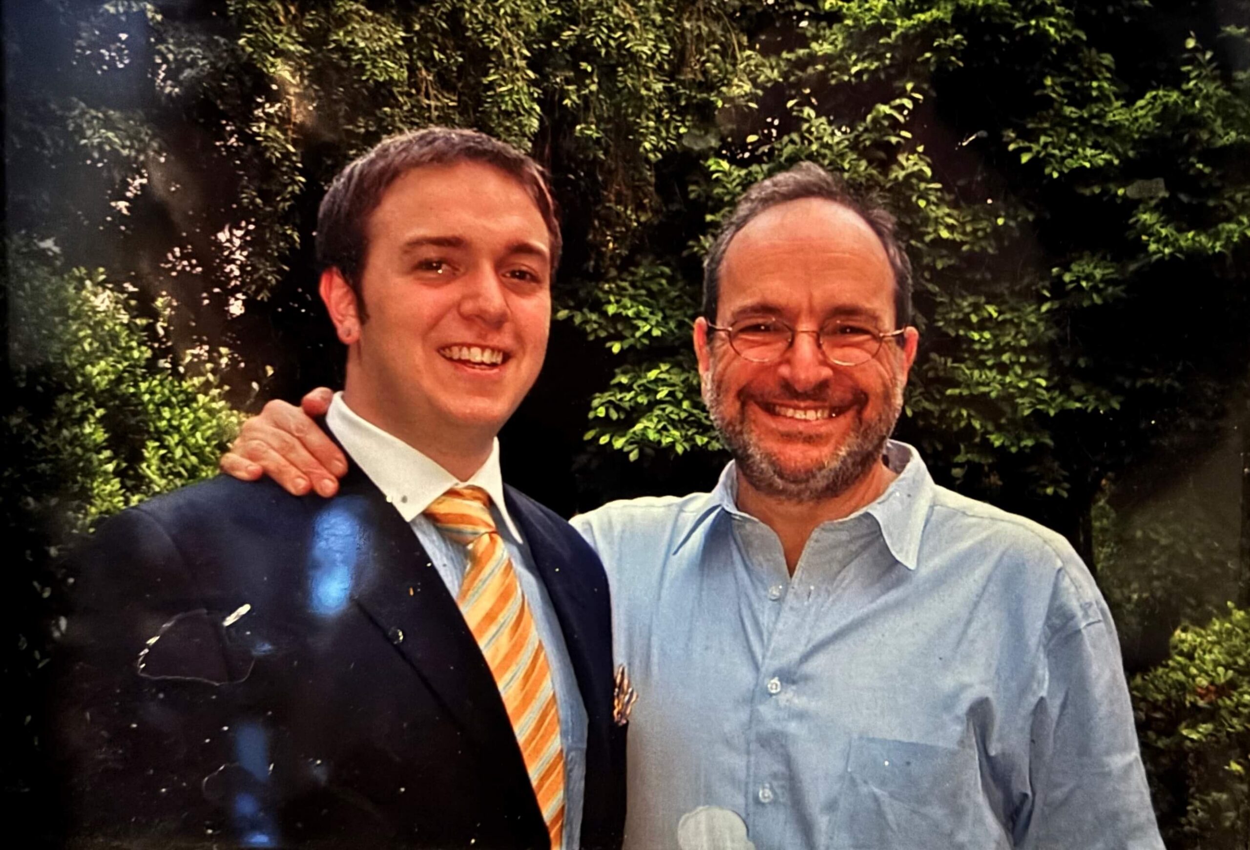 A father and his teenage son pose together.