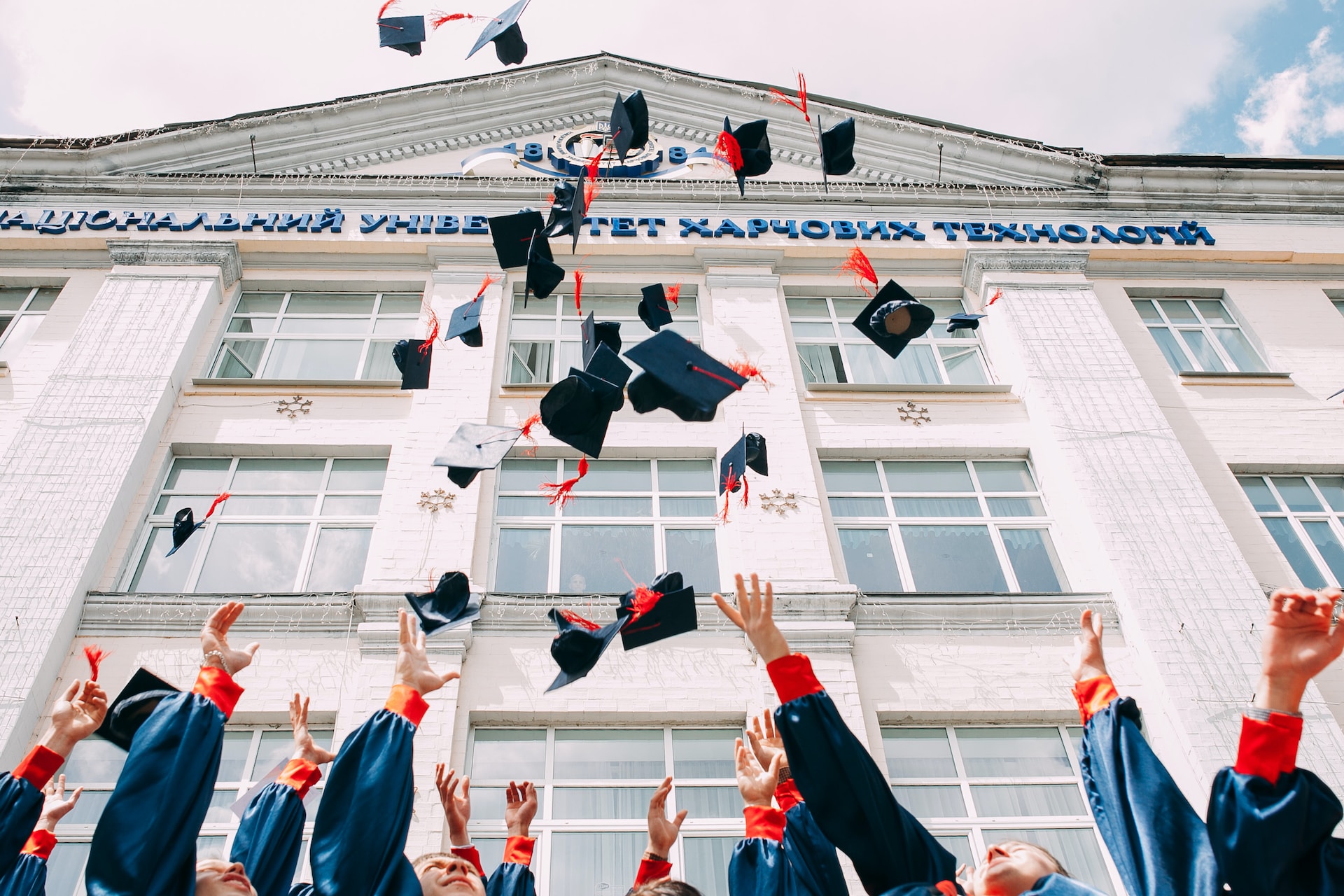 hands throwing graduation caps up on the air